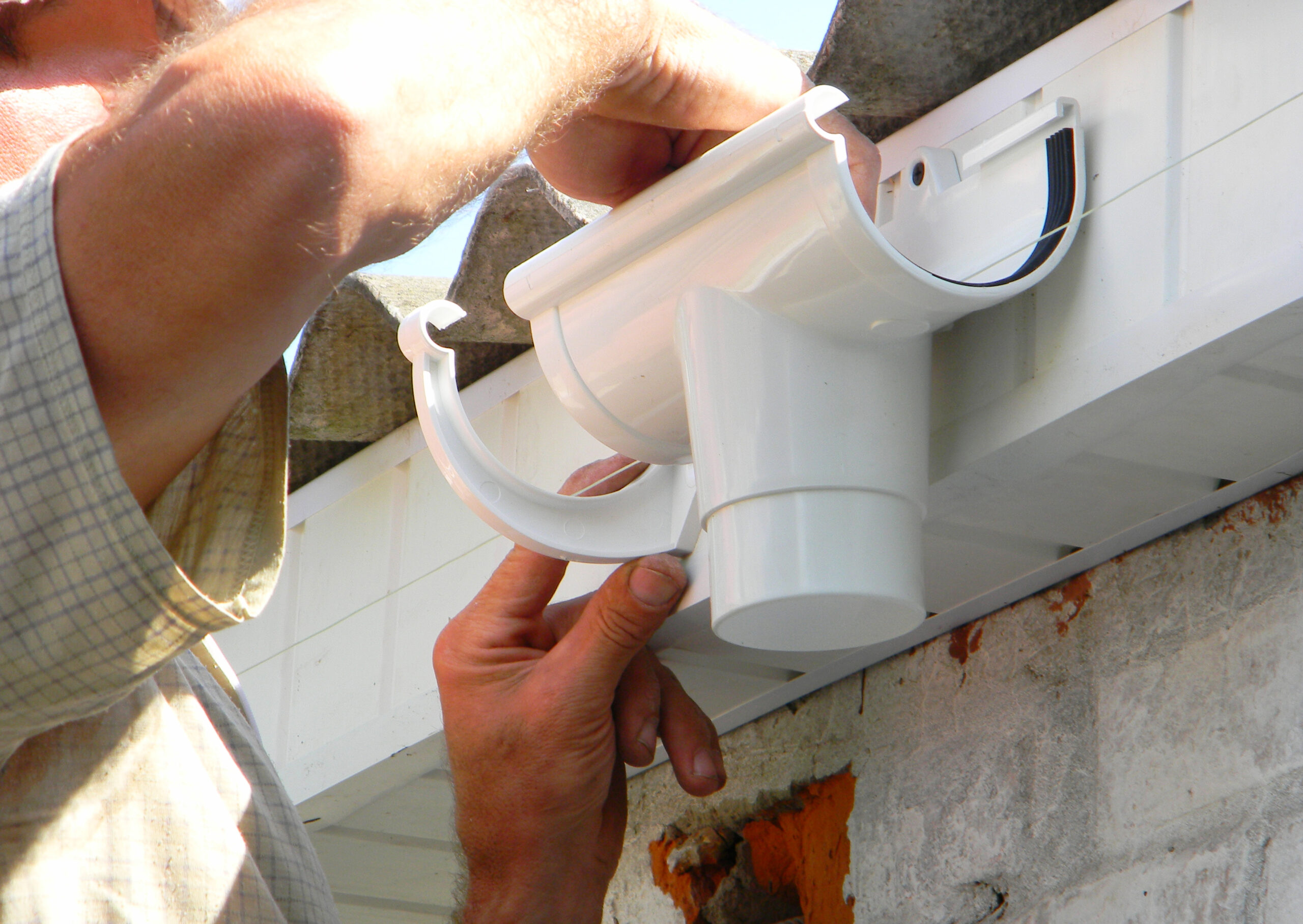 Contractor repairing plastic roof gutter